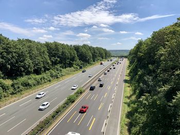 High angle view of highway amidst trees against sky