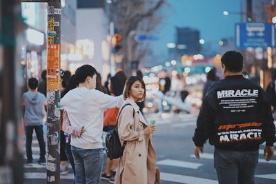 Rear view of people walking on city street