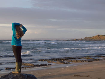 Rear view of woman standing on beach