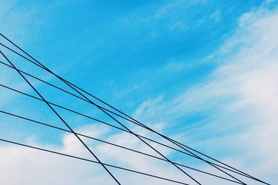 Low angle view of electricity pylon against blue sky