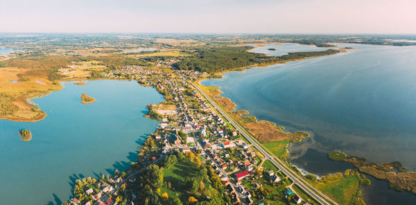 High angle view of city by sea against sky