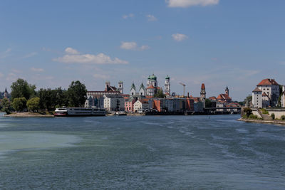 View of buildings at waterfront against cloudy sky