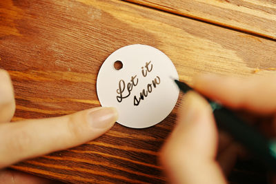 Close-up of hand holding text on table