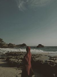 Woman looking at sea against sky