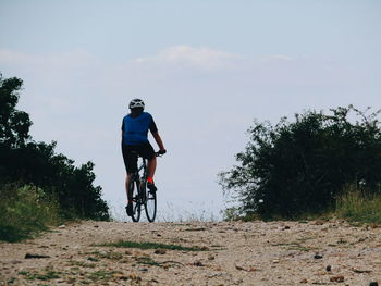 Rear view of man riding bicycle