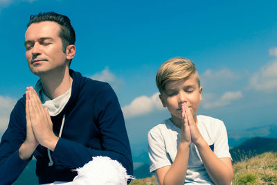 Boys looking away against sky