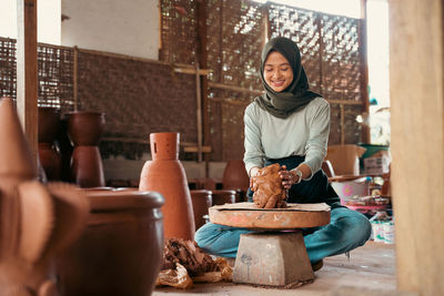 Portrait of young woman sitting on table