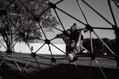 Full length of boy enjoying on jungle gym at park