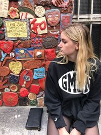 Full length of young woman standing against wall