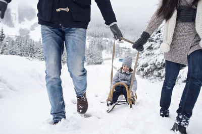 Family with sledge in winter landscape