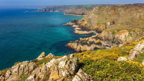 Scenic view of sea by cliff against sky