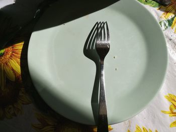 High angle view of fork in plate on table