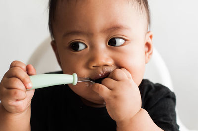 Close-up portrait of cute boy eating at home