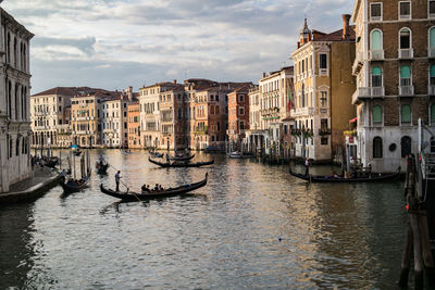 Gondolas in canal against buildings