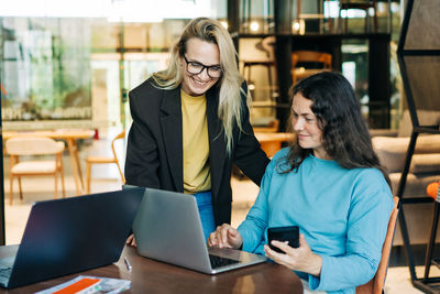 Businesswoman using laptop while sitting on table