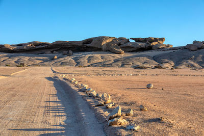 Scenic view of desert against clear blue sky