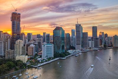 Modern buildings in city against sky during sunset