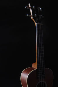 Close-up of guitar against black background