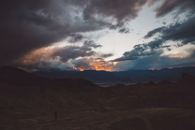 Silhouette of mountain range against cloudy sky