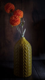 Close-up of orange flower vase on table