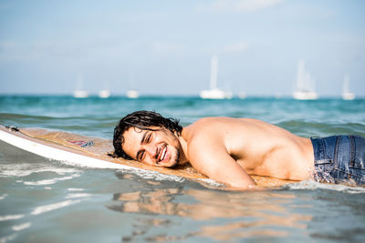 Portrait of young man in sea against sky