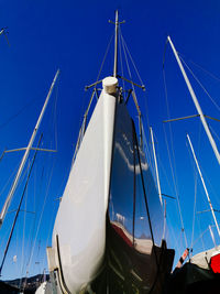 Sailboat moored in sea against clear blue sky