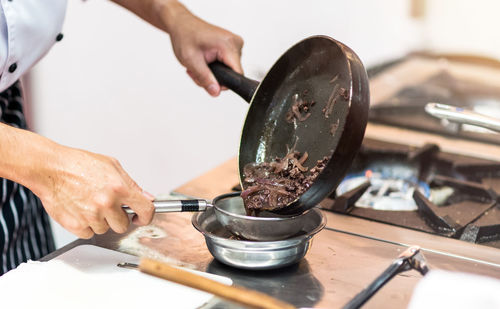 Midsection of man preparing food in kitchen at home