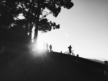 Low angle view of people at observation point against sky on sunny day