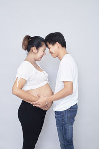 Young couple standing against white background