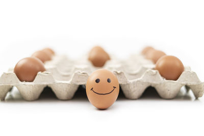 Close-up of broken egg over white background