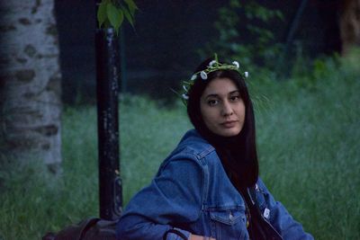 Portrait of a young woman looking away with flowers on her head
