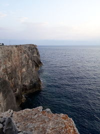 Rock formations by sea against sky