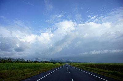 Country road against cloudy sky