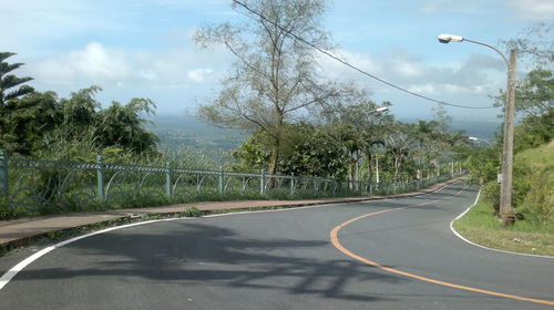 Empty road against cloudy sky