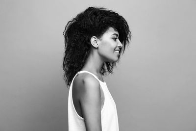 Side view of woman standing against wall