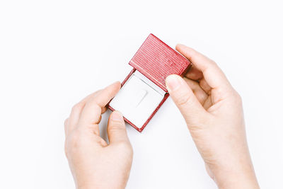 Cropped hands holding jewelry box on white background