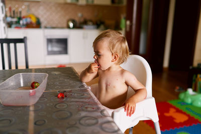 Cute boy looking at table at home