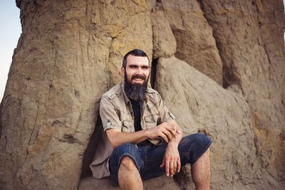 Portrait of young man sitting on rock