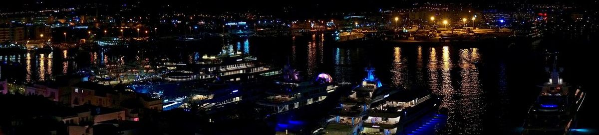 High angle view of illuminated buildings by river at night