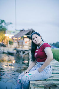 Portrait of smiling young woman sitting outdoors