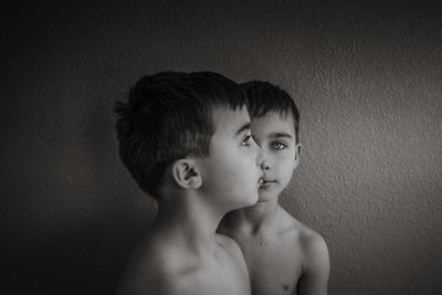 Shirtless boys against wall