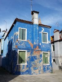 Low angle view of abandoned built structure against blue sky