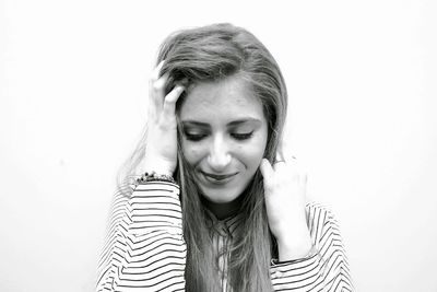 Portrait of young woman against white background