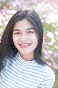 Close-up portrait of young woman smiling at park