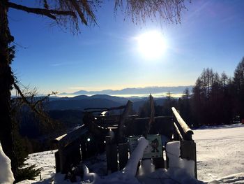 Scenic view of snow covered field against sky on sunny day