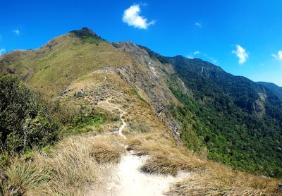 Scenic view of mountains against blue sky