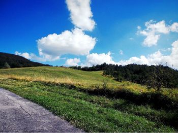 Scenic view of grassy field against cloudy sky