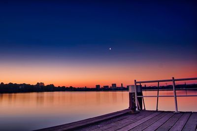 Scenic view of lake against sky at sunset