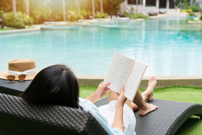 Rear view of woman reading book