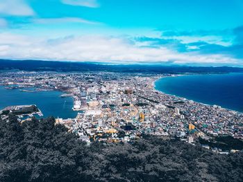 High angle view of city by sea against sky